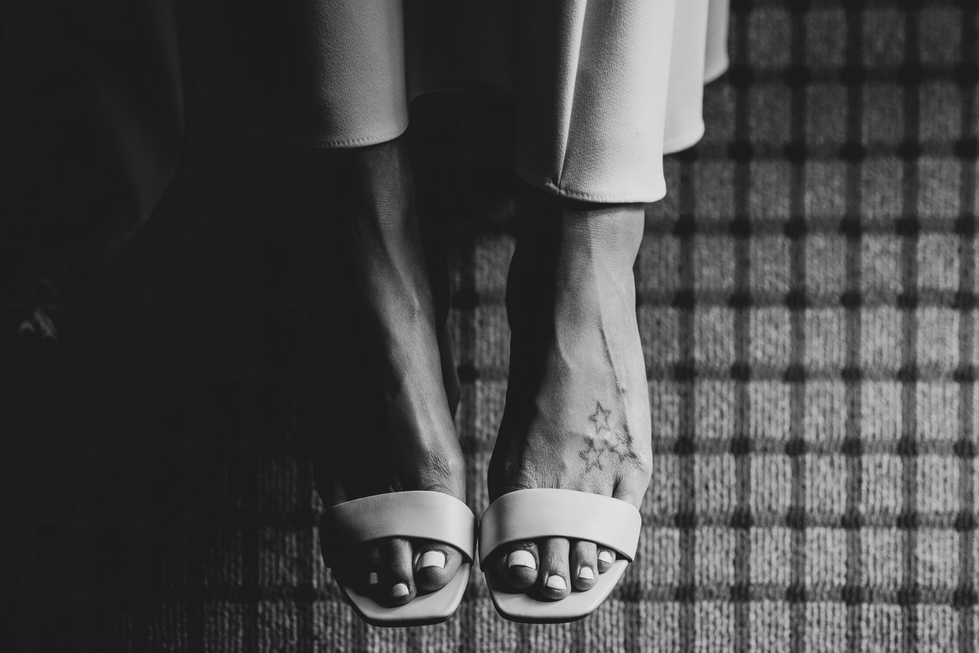 The bride's feet in her wedding shoes, shot artfully and in black and white