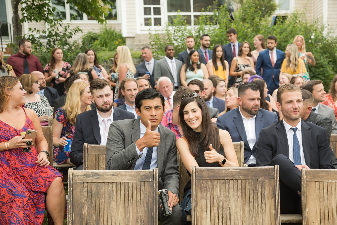 Guests give the photographer a thumbs up just before the wedding ceremony begins at a Massachusetts barn