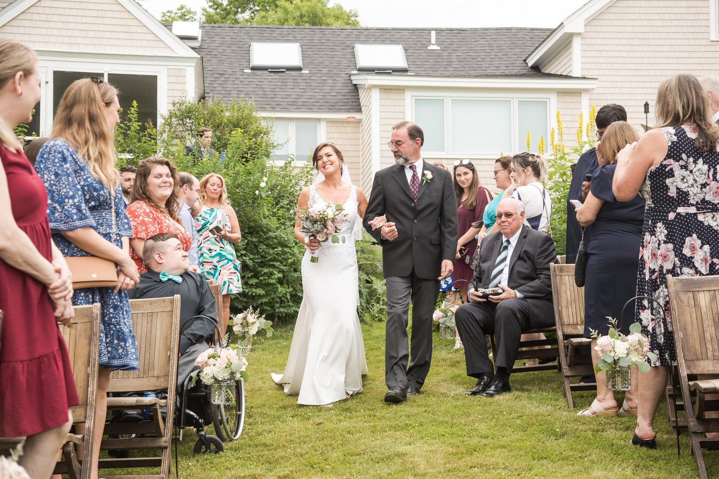 The bride and her father walking down the aisle at a barn wedding in Massachusetts