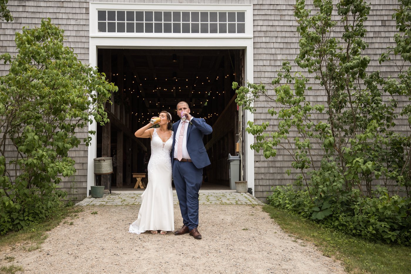 The bride and groom drink craft beer at a barn wedding in Massachusetts