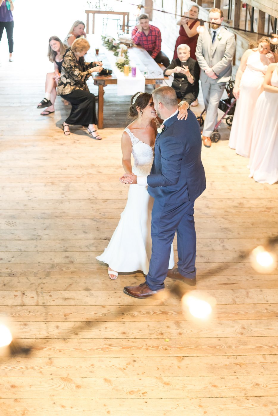 The bride and groom slow dancing in the barn
