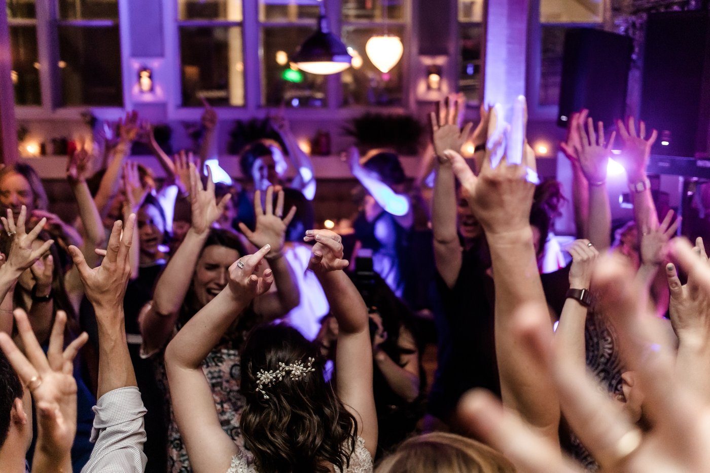 A sea of hands are in the air at an Alden and Harlow wedding in Cambridge, MA, photographed by the artistic Boston wedding photographer duo Spagnolo Photography