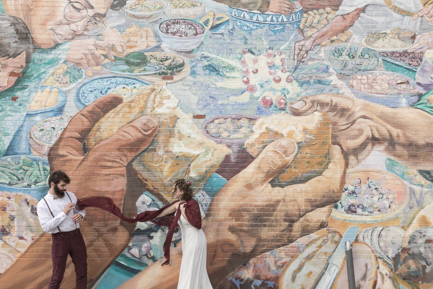 Boston wedding photographers Spagnolo Photography's creative and candid portrait of a hip couple in front of a vibrant mural in Cambridge