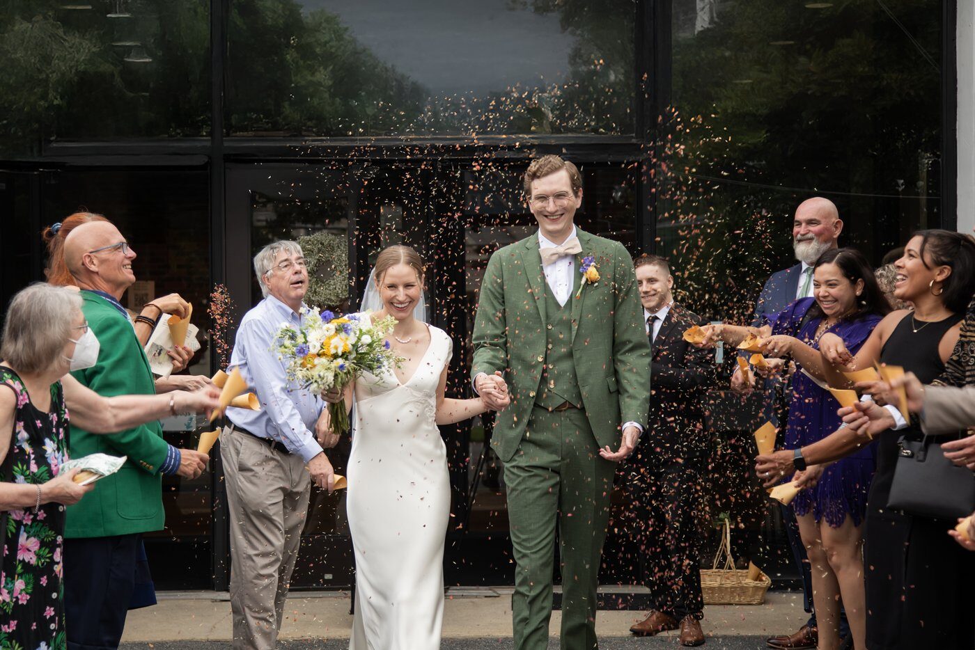 A bride and groom rained with flower confetti after their wedding ceremony at the First Church in Melrose, captured by Boston's most creative wedding photographers, Spagnolo-Photography.