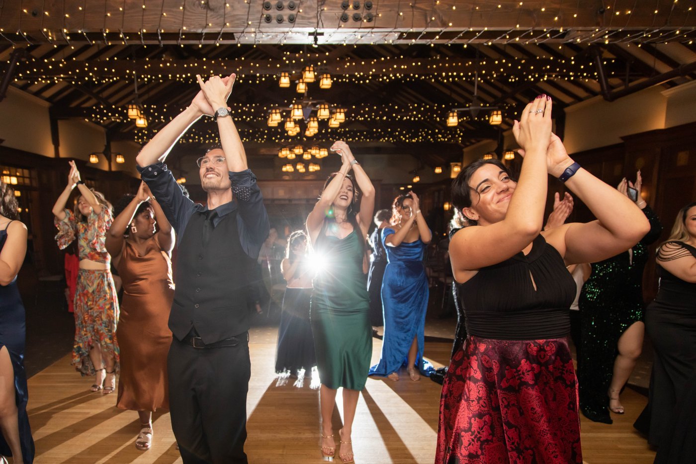Guests dancing in unison at a wedding at the Garden House at Look Park in Northampton, photographed with the use of backlighting flash by Boston's best creative wedding photographers, Spagnolo Photography.