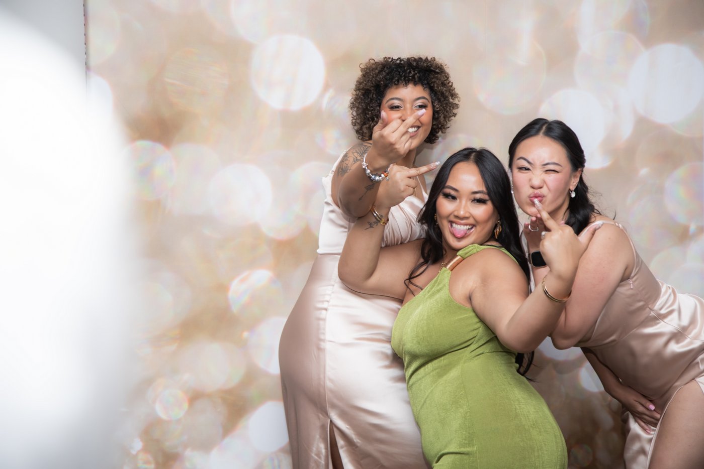 Three female wedding guests pose for the camera at a Boston wedding, photographed creatively by Boston wedding photographers Spagnolo Photography