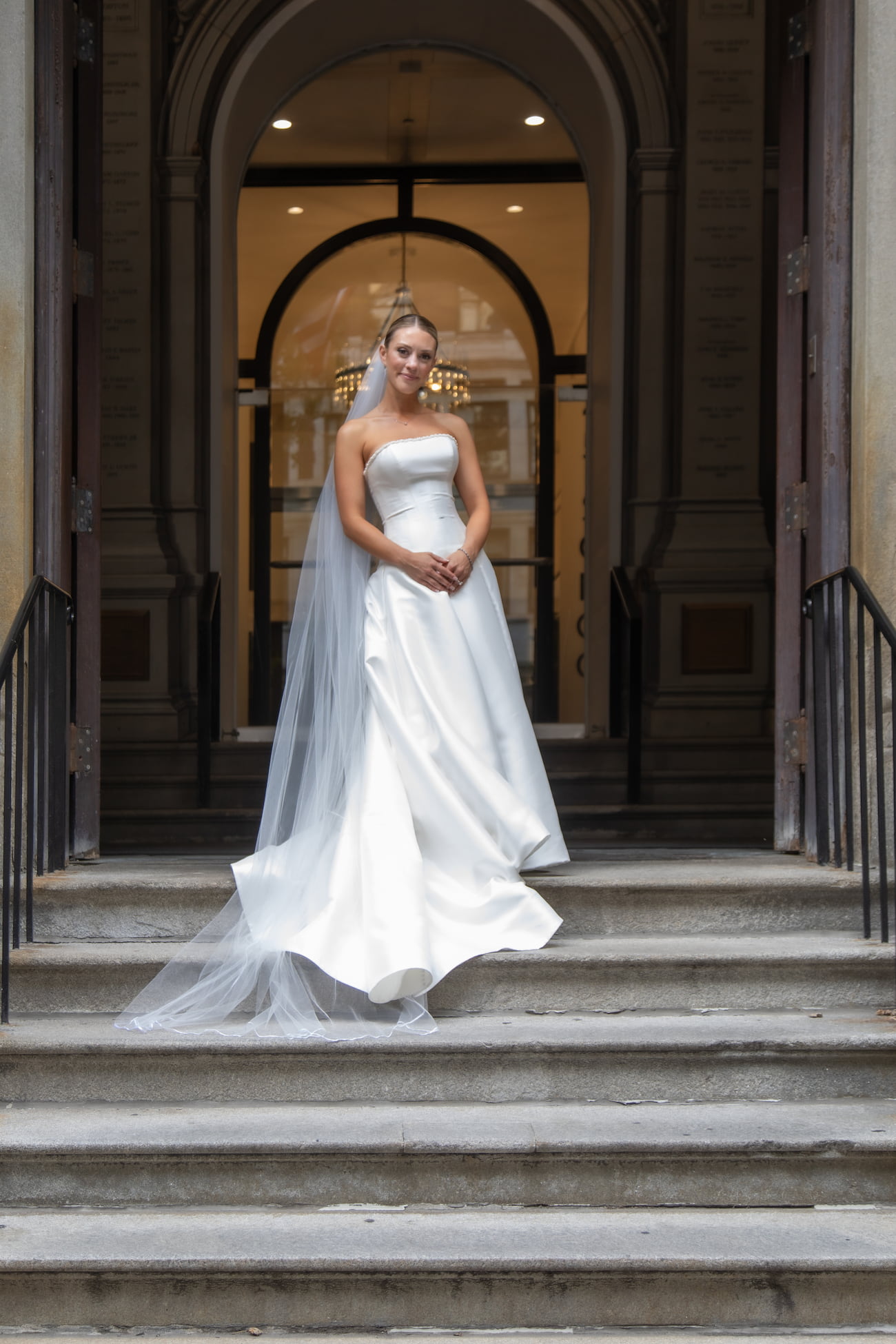 A bride poses on the steps of the Old City Hall in Boston for her Boston wedding photographers Spagnolo Photography