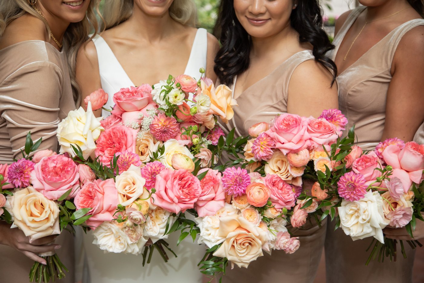 A close-up shot of a bride and her bridesmaids' flower bouquets as they are held close together, photographed at Boston's Post Office Square
