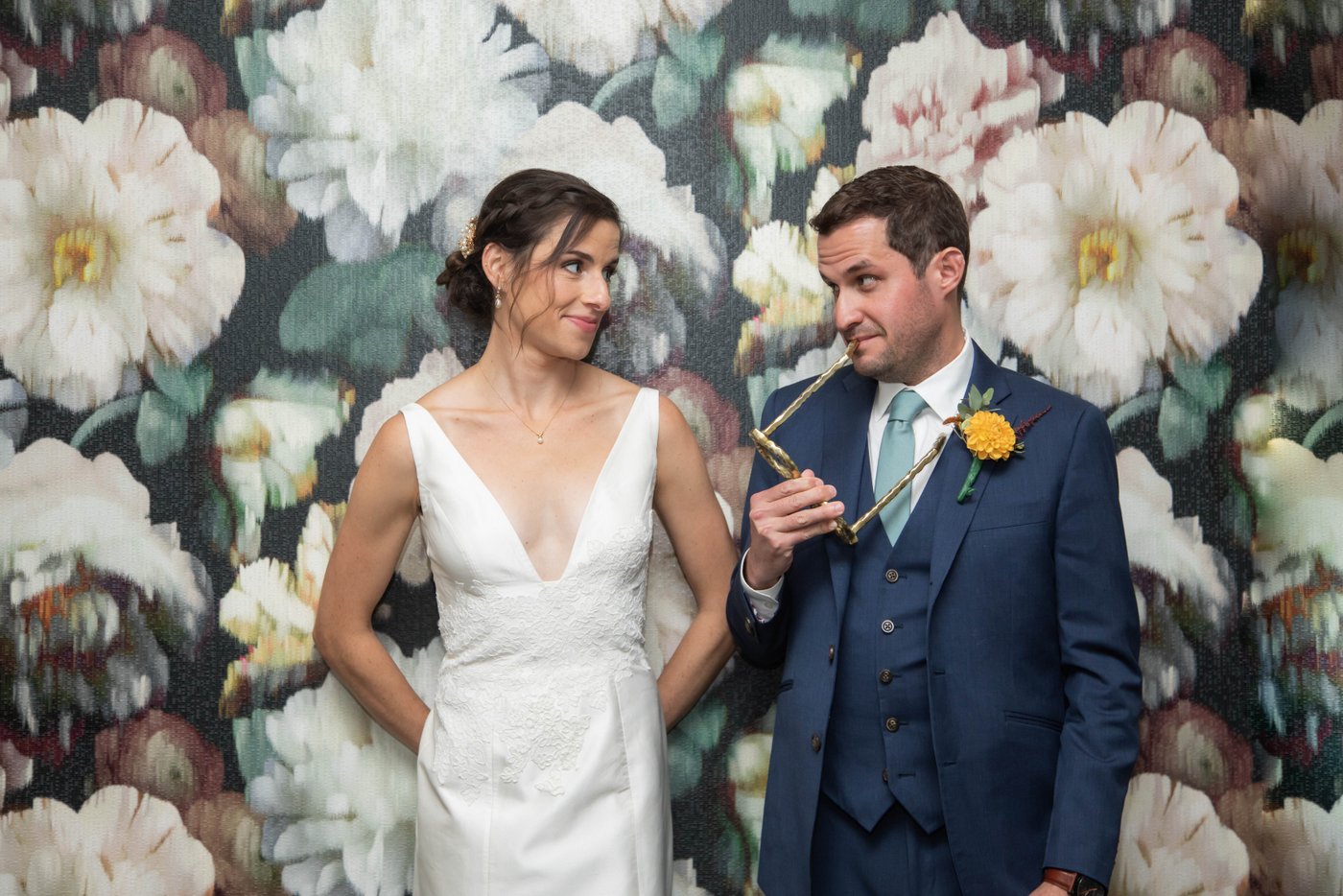 Bride and groom standing against a floral wallpaper before their fall wedding in Brookline, MA, photographed in a natural candid style by creative Boston wedding photographers Spagnolo Photography