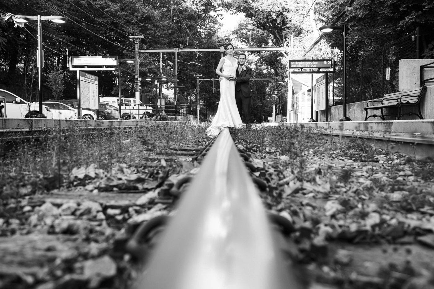 A black and white portrait of a bride and groom on train tracks near the Riverway Park in Brookline, before their fall wedding celebrations