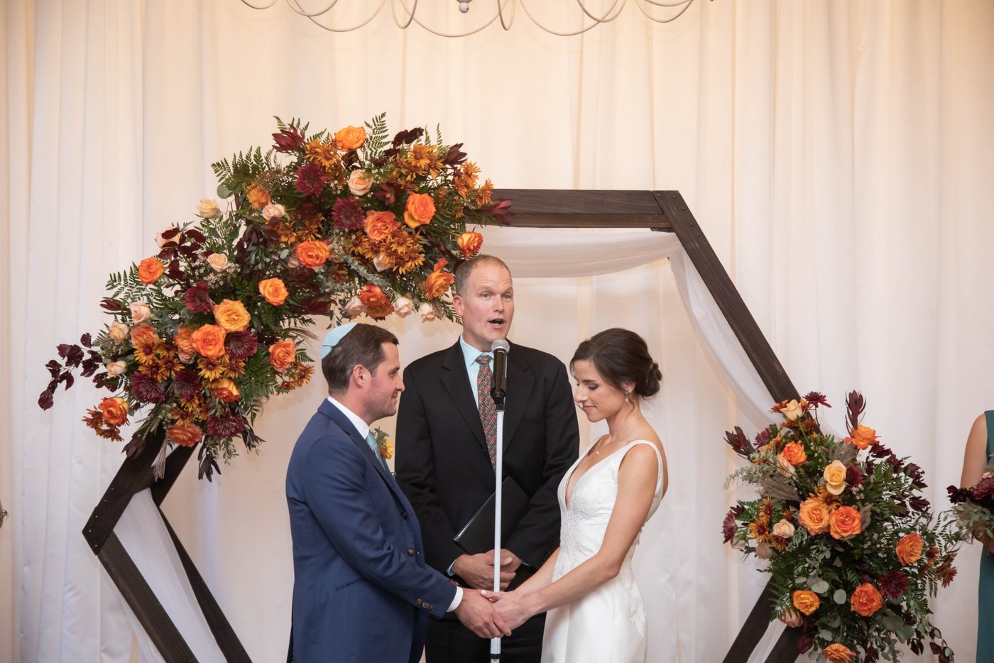 Couple at altar at a fall Jewish ceremony at Alden Castle in Brookline