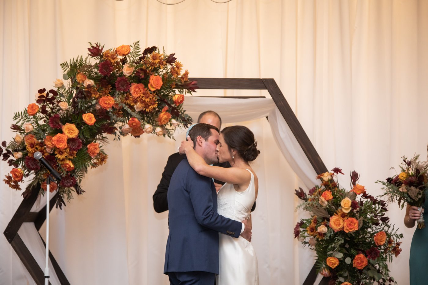 Bride and groom kiss at the altar in a fall ceremony in Brookline