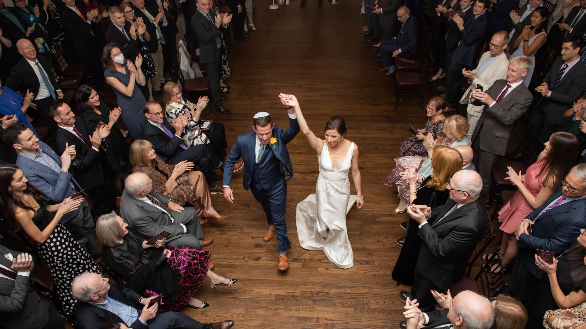 The newlyweds exiting the ceremony space at their fall Jewish wedding in Brookline, MA, photographed by Boston wedding photographers Spagnolo Photography
