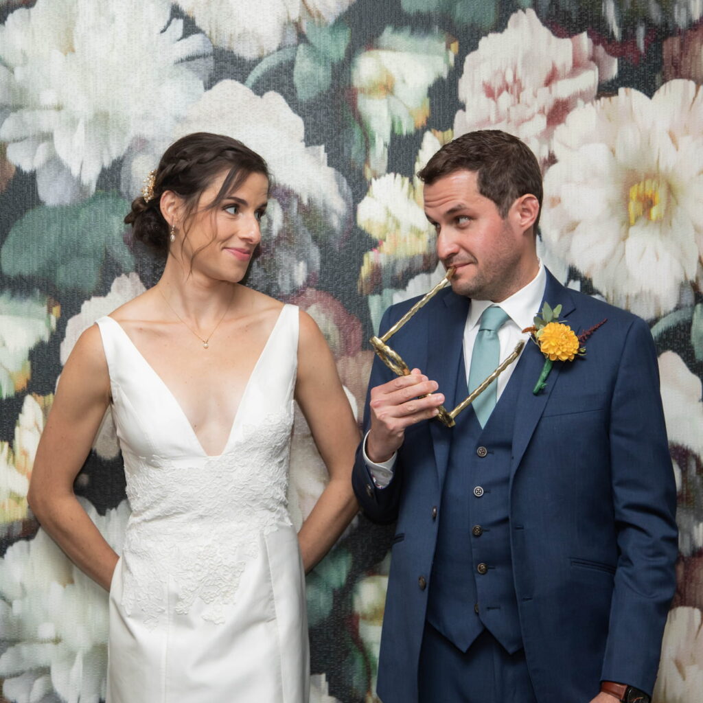 Bride and groom standing against a floral wallpaper before their fall wedding in Brookline, MA, photographed in a natural candid style by creative Boston wedding photographers Spagnolo Photography