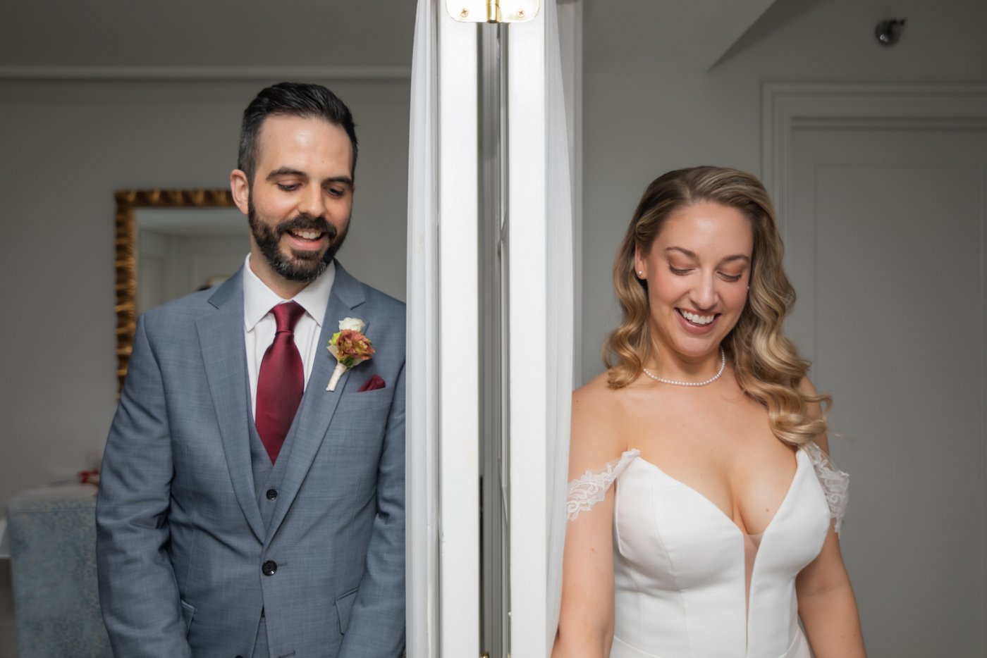 A bride and a groom exchange a few words while separated by a wall, before their wedding