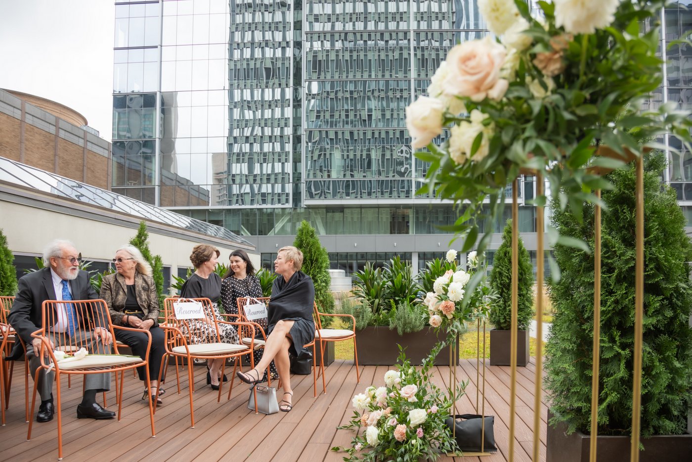 Guests conversing as they wait for the rooftop wedding ceremony to start at Terra at Eataly in Boston