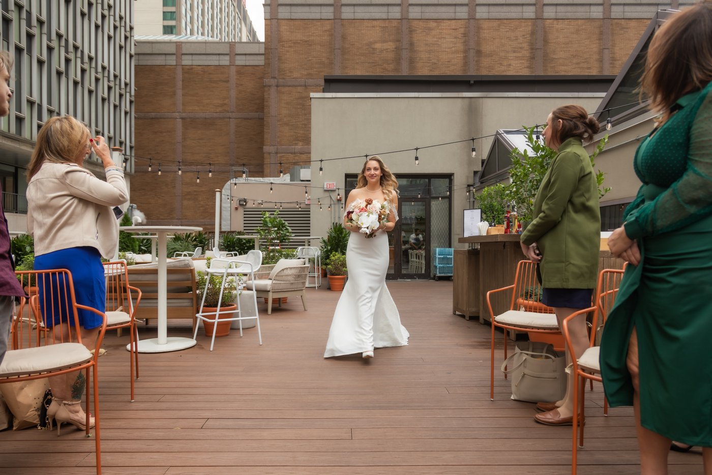 The bride walking down the aisle during her rooftop wedding ceremony at Terra at Eataly in Boston