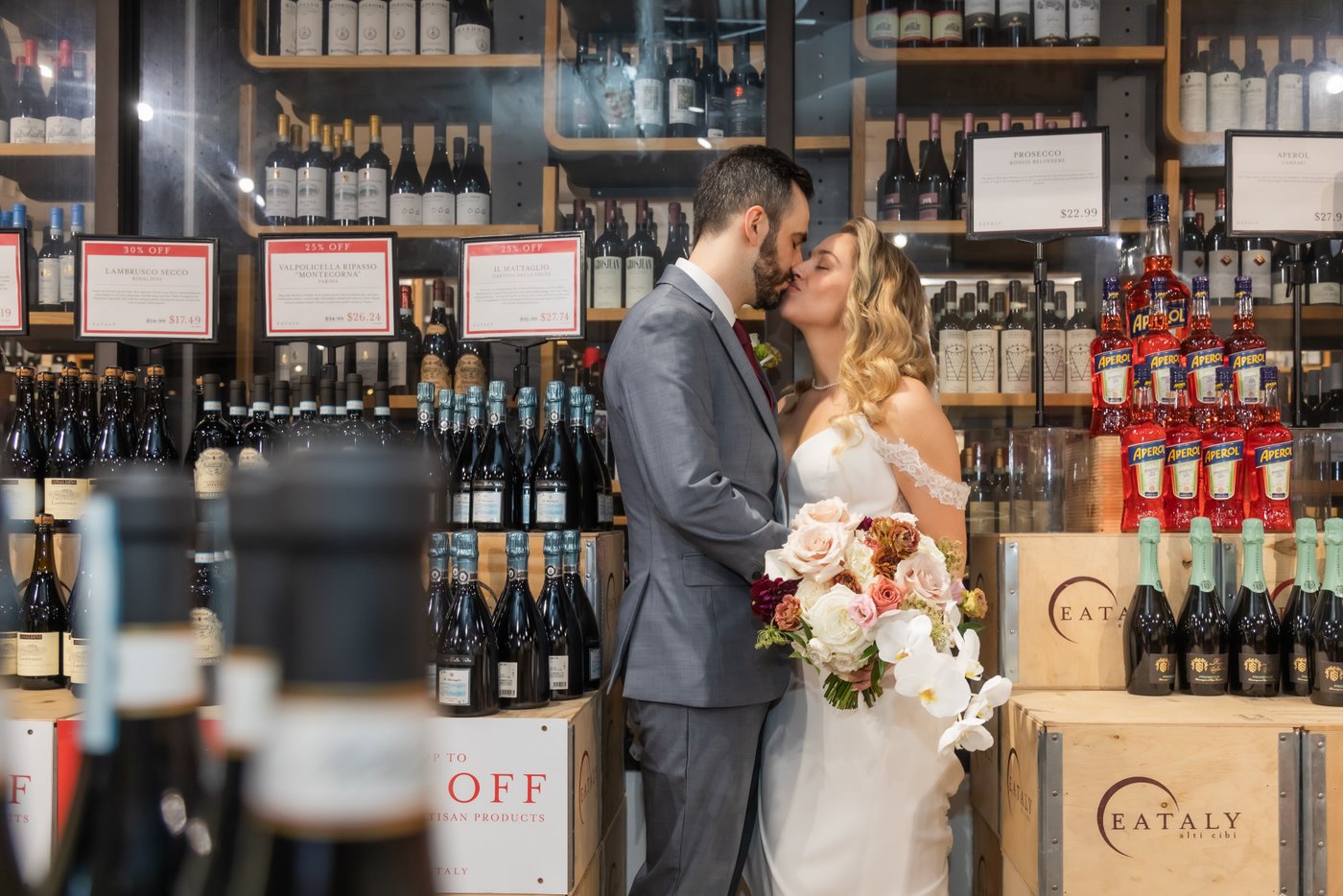 The bride and groom kissing in the wine cellar at Terra at Eataly during their wedding reception
