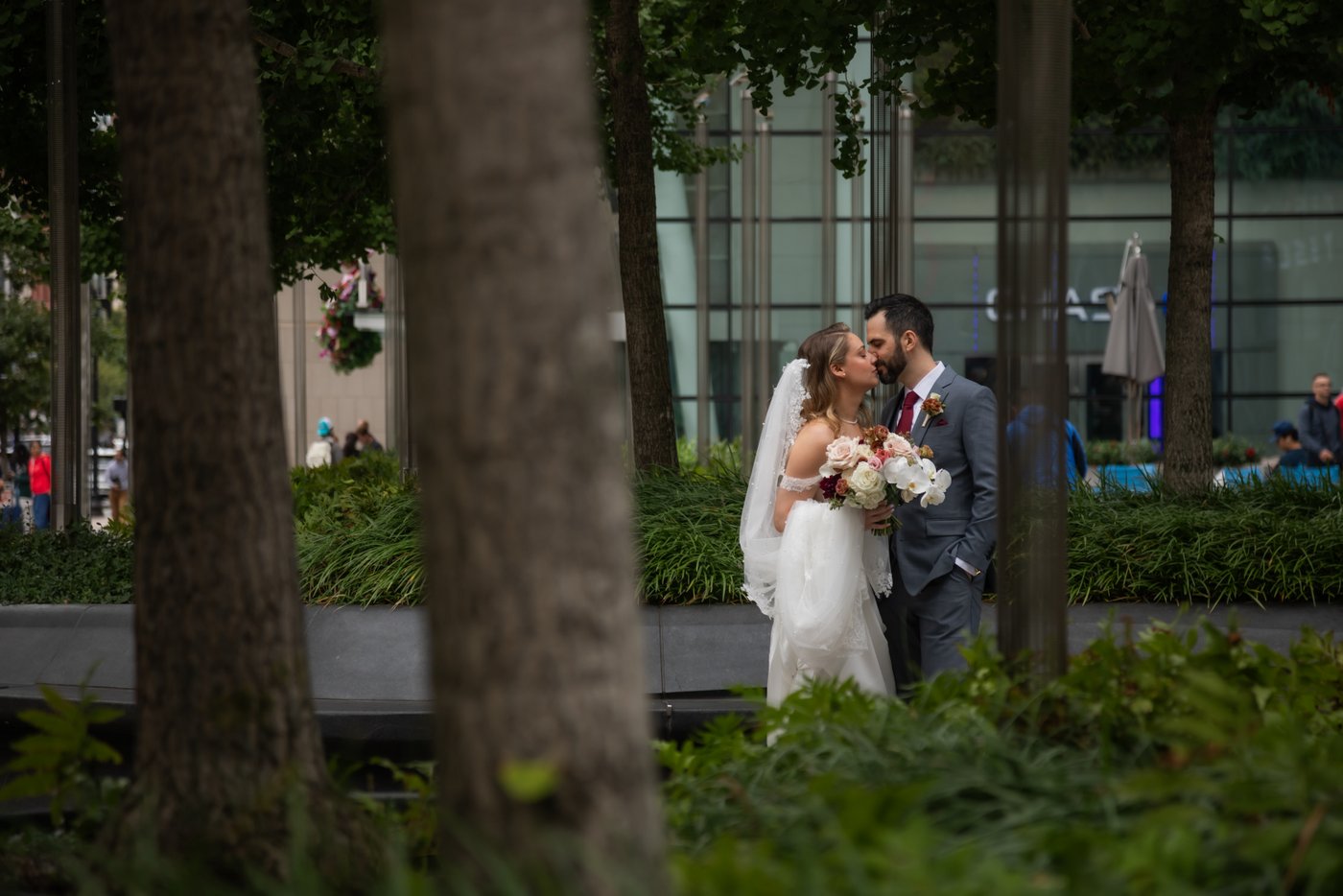 A bride and a groom kissing outside the Prudential Center in Boston