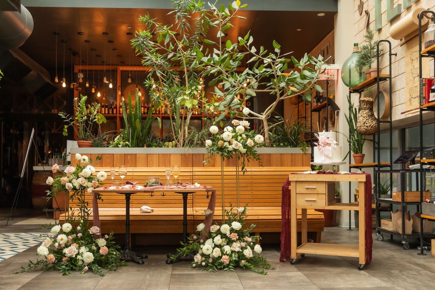 Wedding florals mixed with Terra's lush green plants during the micro wedding reception at this Boston venue