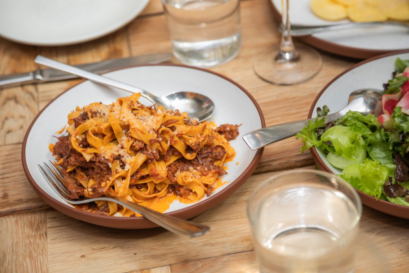 A bowl of pasta Bolognese sprinkled with parmesan cheese on a table at a Terra at Eataly wedding in Boston