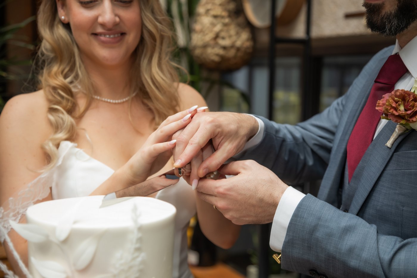 A close-up of the bride and groom cutting the wedding cake