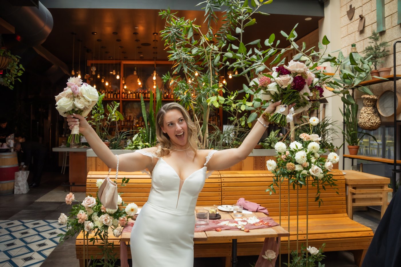 The bride holds up two bouquets of flowers