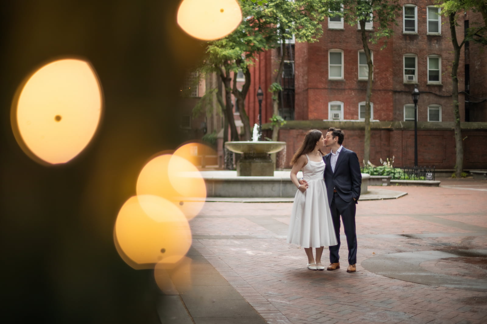 A bride and a groom kiss in Boston's North End Neighborhood on their elopement day, photographed in a creative and candid style by Boston wedding and elopement photographers Spagnolo Photography