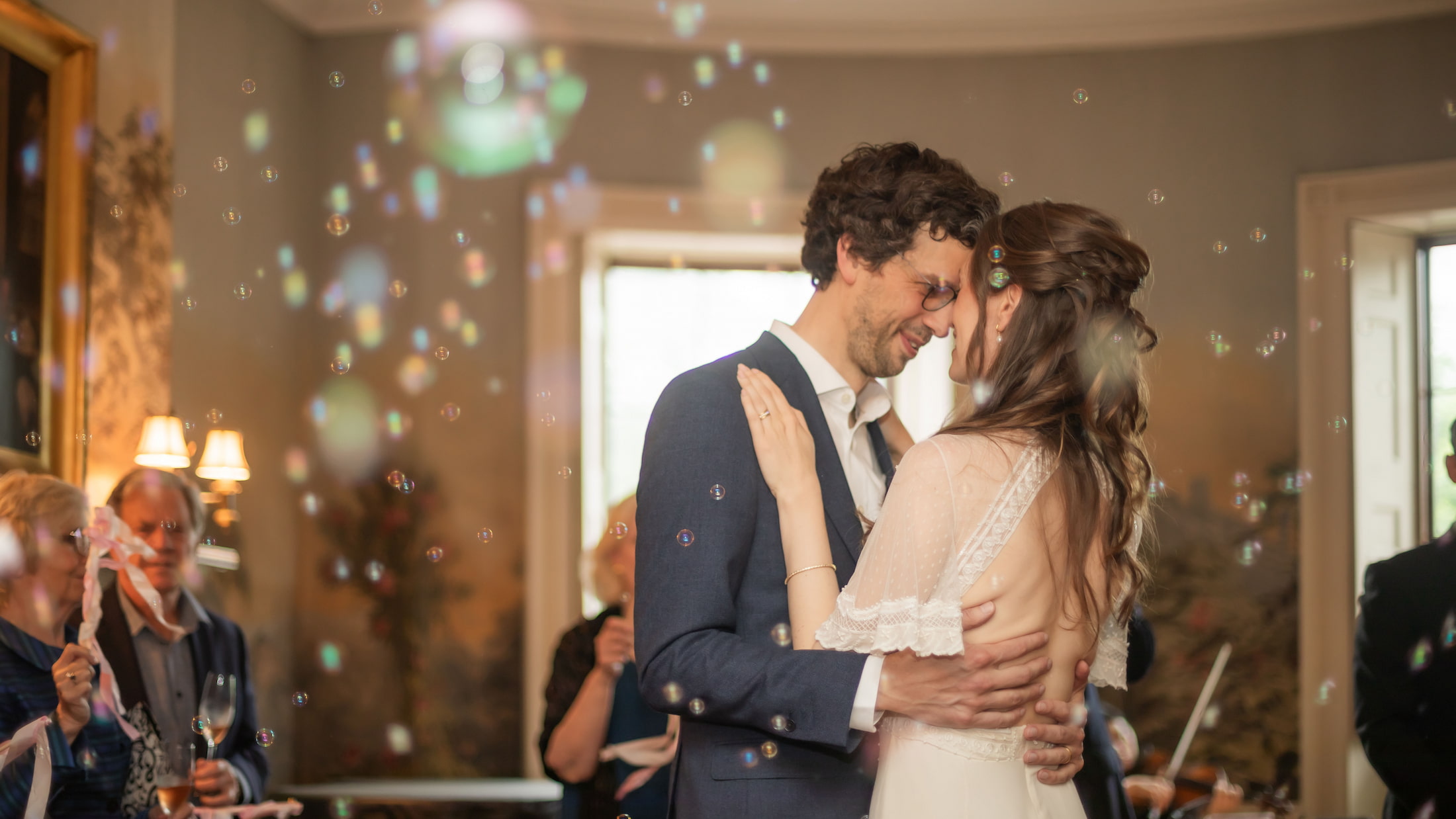 A bride and a groom hold each other as they dance their first dance during their wedding at the King's Chapel Parish House in Boston's Beacon Hill neighborhood.