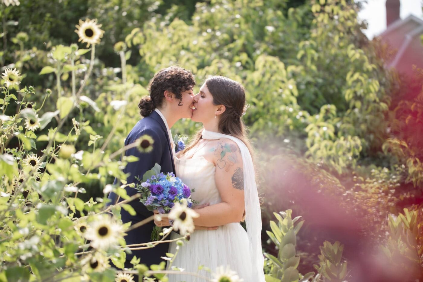 A couple kisses in the Rope's Mansion garden in Salem, MA, on their wedding day, photographed by micro wedding photographers Spagnolo Photography