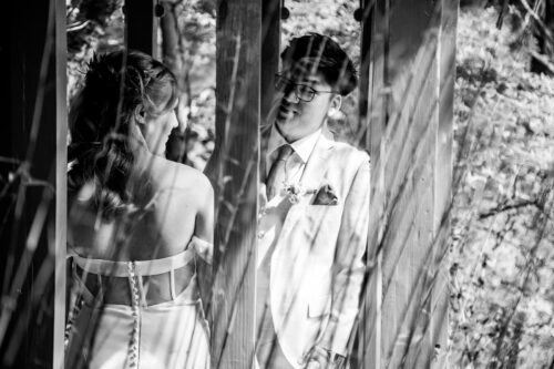An artistic black and white portrait of a bride and groom in the Chinese garden house at the Long Hill Estate in Beverly, MA, photographed by Spagnolo Photography for a micro-wedding photography package.