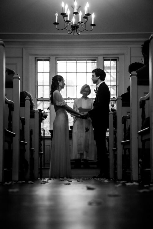 A black and white image of a bride and groom during a King's Chapel wedding ceremony