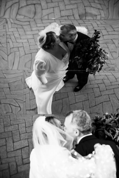 A black and white image of bride and groom's warped reflections at MIT in Cambridge, MA, following their MIT chapel micro-wedding, photographed by Spagnolo Photography