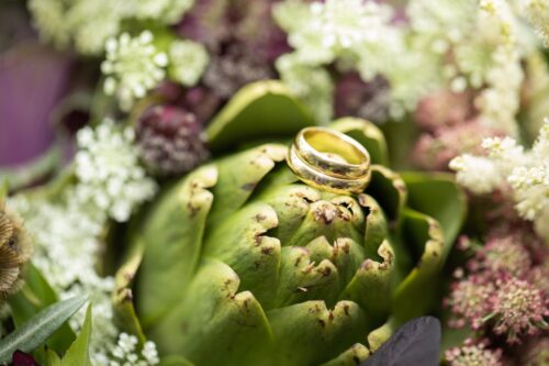 Wedding bands on an artichoke that's part of a floral centerpiece at a Museum of Science Wedding in Boston.