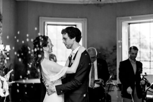 A black and white photo of a bride and a groom dancing their first dance during their wedding at the King's Chapel Parish House in Boston's Beacon Hill neighborhood.
