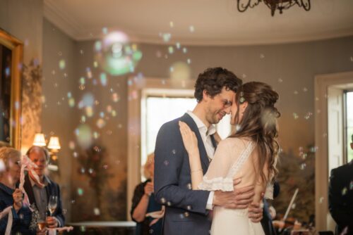 A bride and a groom hold each other as they dance their first dance during their wedding at the King's Chapel Parish House in Boston's Beacon Hill neighborhood.